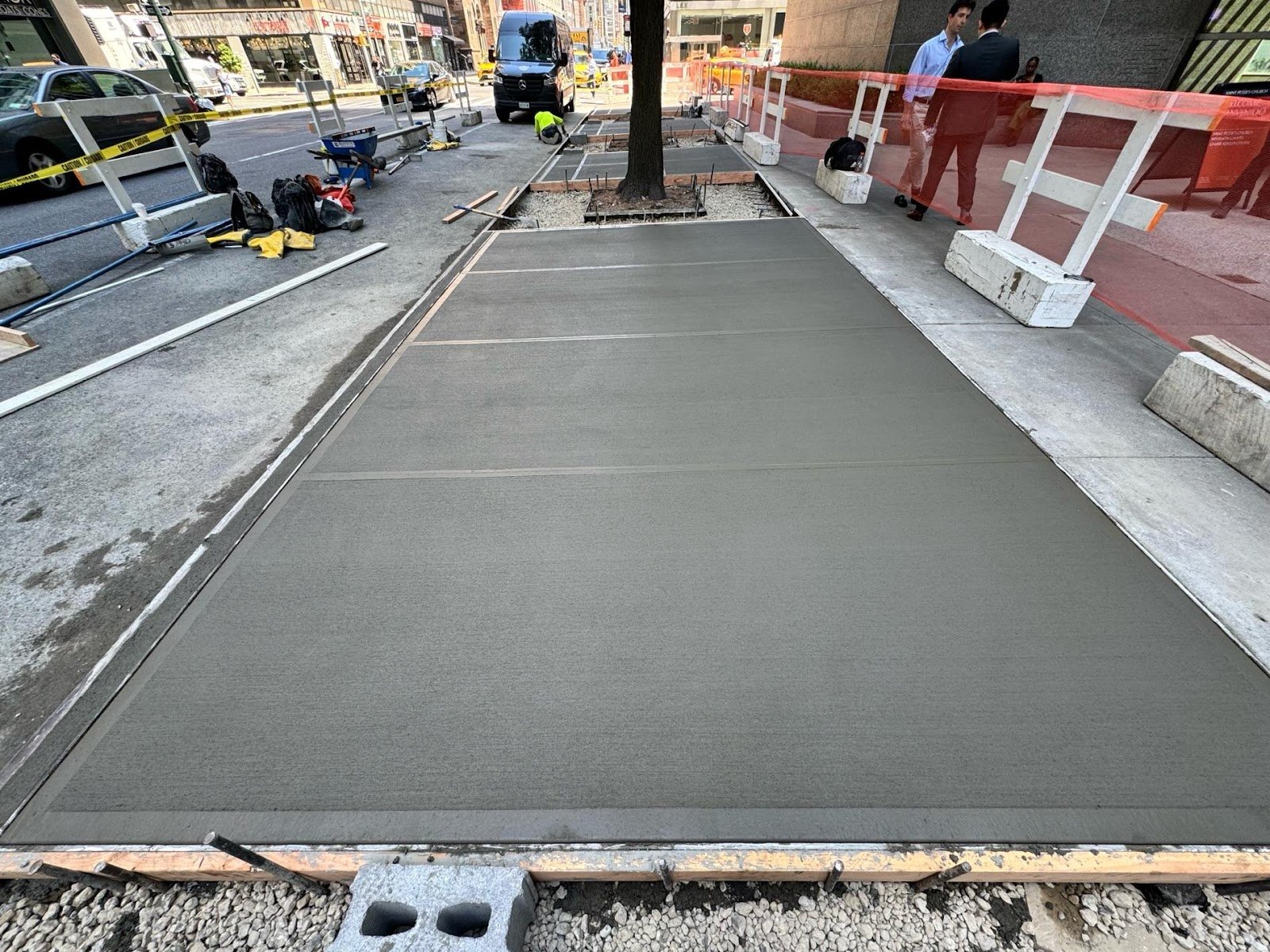 Fresh concrete sidewalk installation in Manhattan. Concrete services.