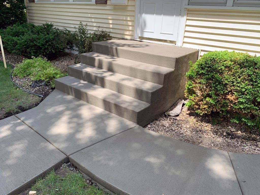 Newly poured concrete steps and walkway leading to a house entrance. Concrete services in Manhattan.
