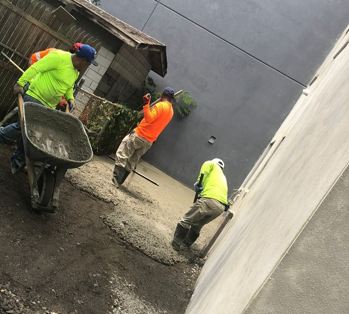 Testimonials/selling points text listing reasons to hire, next to a photo of workers pouring concrete.