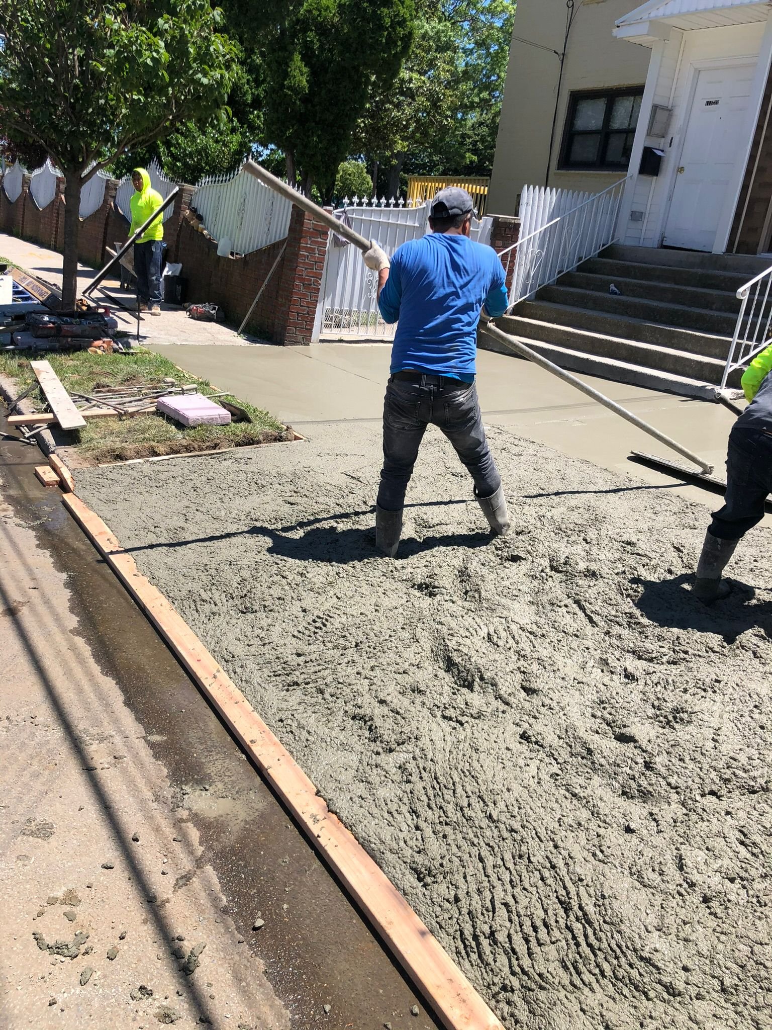 Workers installing, repairing, or finishing concrete surfaces on residential and commercial properties in New York City.