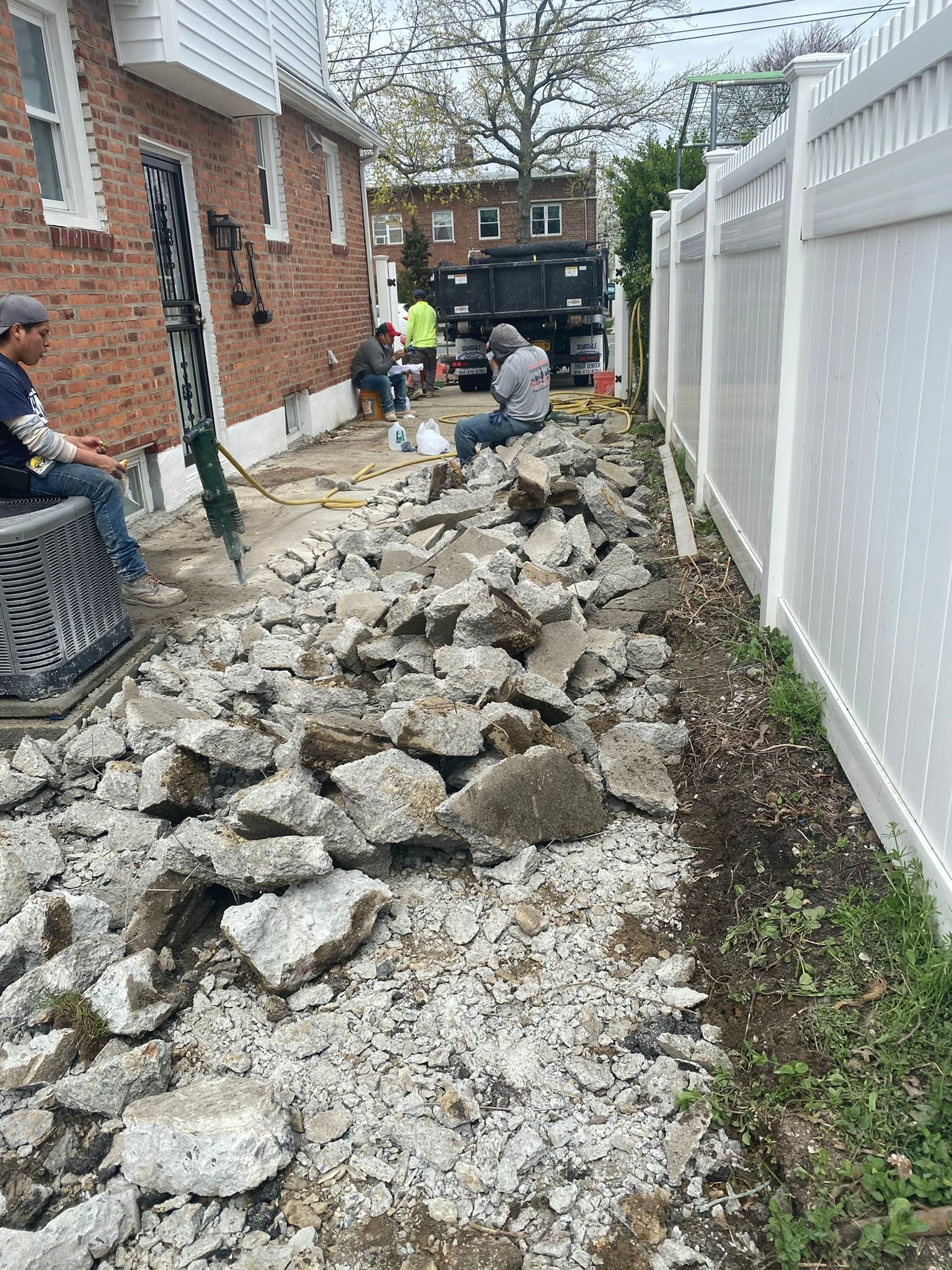 Workers performing concrete construction services such as driveways, patios, sidewalks, slabs, foundations, repairs, and leveling in New Rochelle, NY.