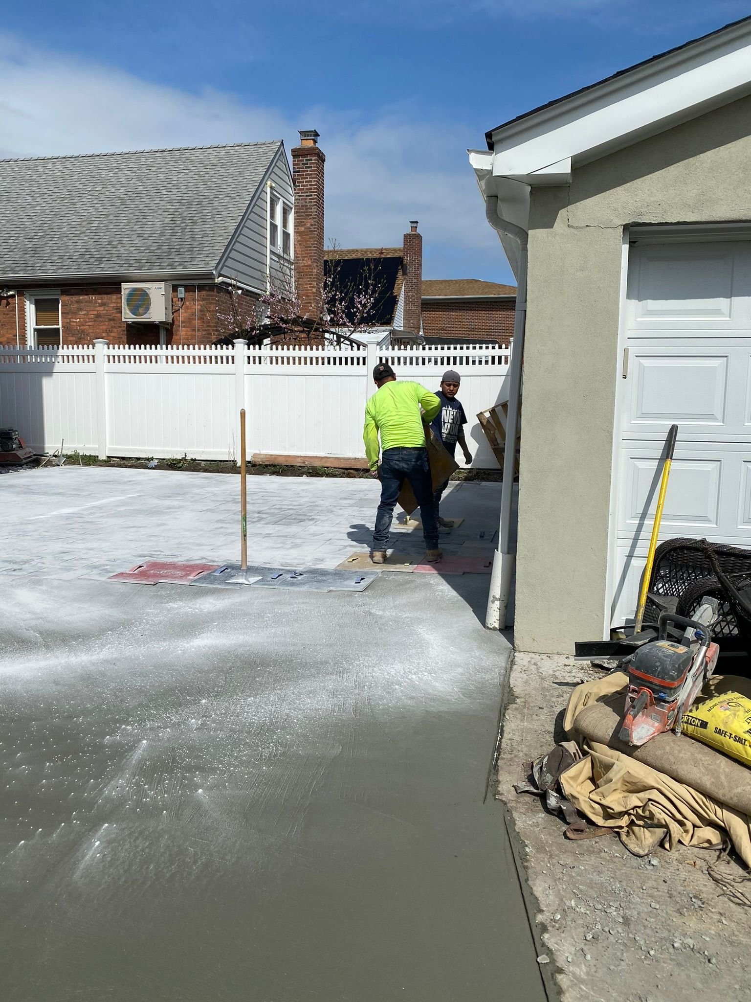 Contractor applying sealant to a concrete walkway to protect it from water and salt damage.