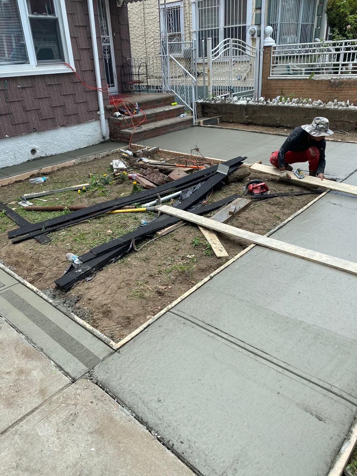 Construction crew working on various concrete projects—driveways, patios, sidewalks, foundations, steps, slabs, and repairs—at residential and commercial sites in Mount Vernon, NY.