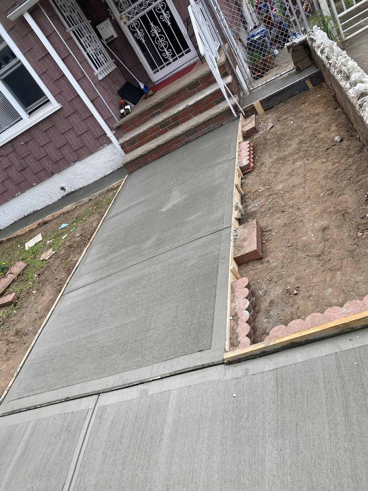 Workers installing, repairing, or finishing concrete surfaces on residential and commercial properties in New York City.