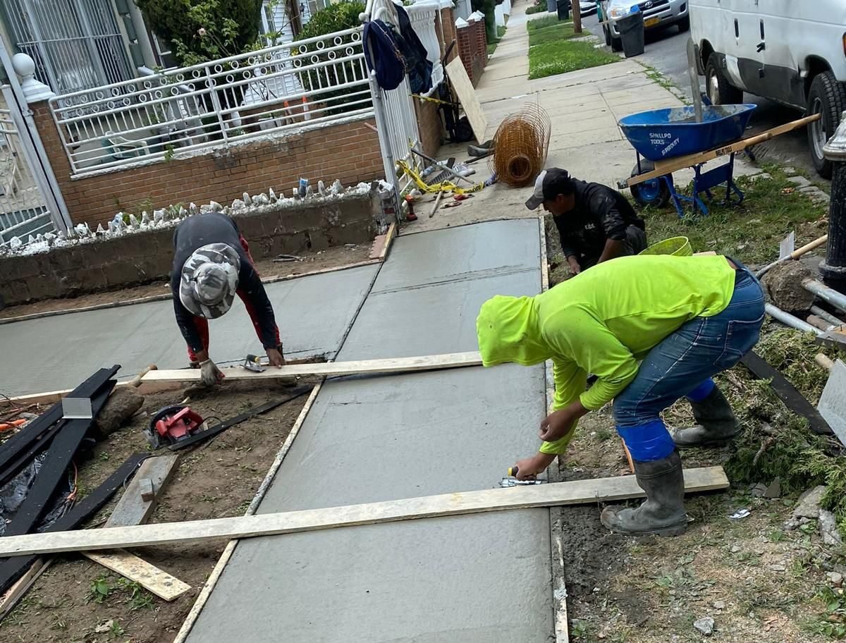 Workers performing concrete construction services such as driveways, patios, sidewalks, slabs, foundations, steps, leveling, repairs, and sealing in Yonkers, NY.