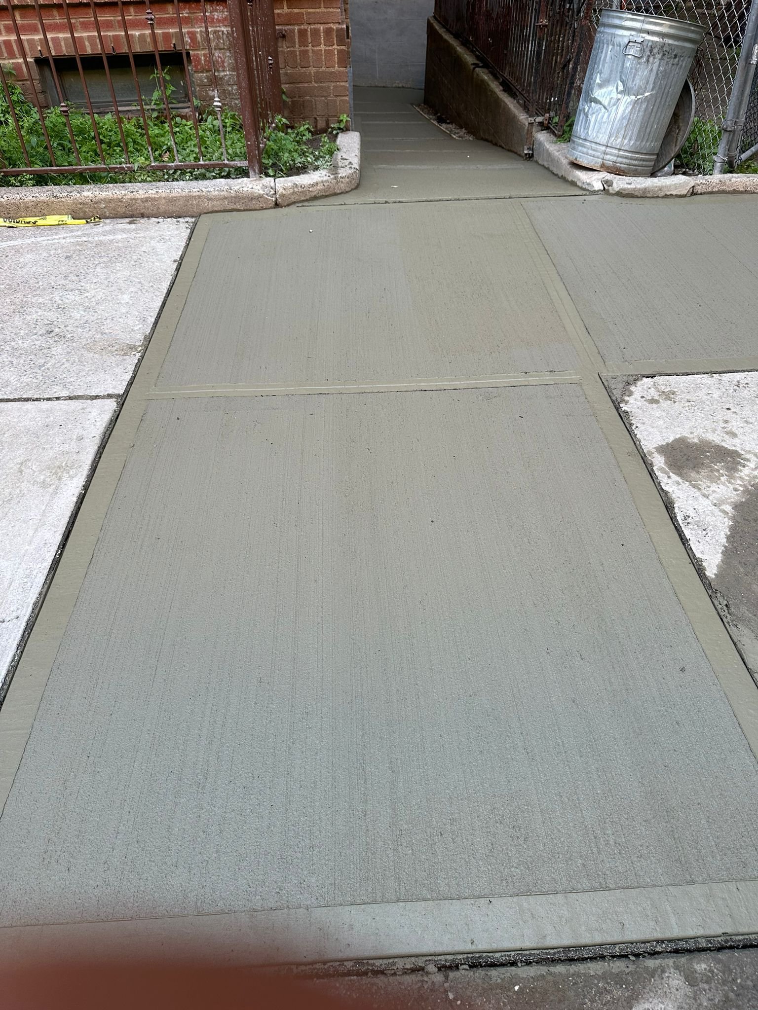 Workers performing concrete construction services such as driveways, patios, sidewalks, slabs, foundations, steps, repairs, and leveling in Queens, NY.