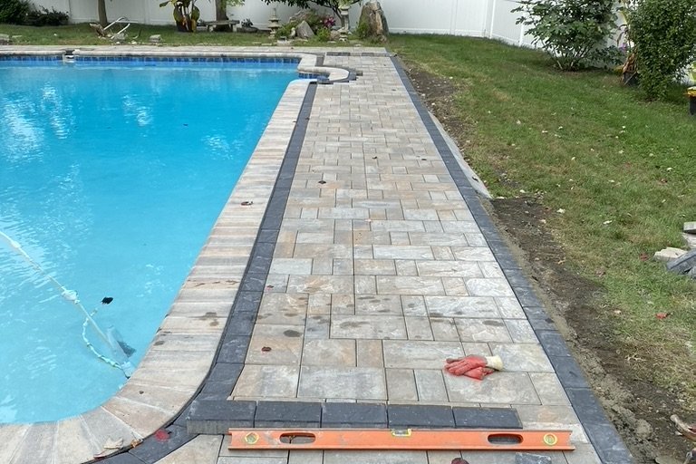 Interlocking pavers being installed over a compacted base in NYC